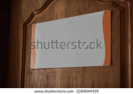 White plaque on brown wooden doors.