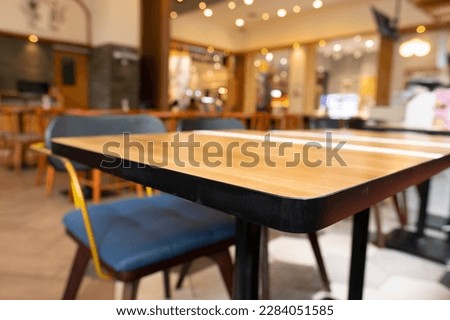 Blurry cafe, restaurant or coffee shop background and perspective view of wooden table corner. Royalty-Free Stock Photo #2284051585