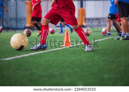 Children playing control soccer ball tactics cone on a grass field with for training background Training children in Soccer