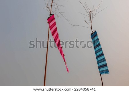 Colourful handmade traditional Lanna Tung hanging on the bamboo pole in Thai Temple, Tung is a symbol of the northern style object, Used to decorate or perform rituals according to beliefs, Thailand. Royalty-Free Stock Photo #2284058741