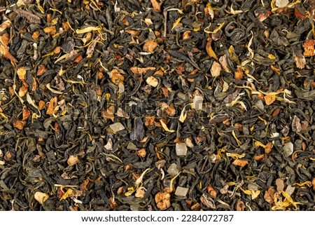 A large amount of dry green tea with pieces of fruit, delicious and fragrant green tea with a pleasant aroma Royalty-Free Stock Photo #2284072787
