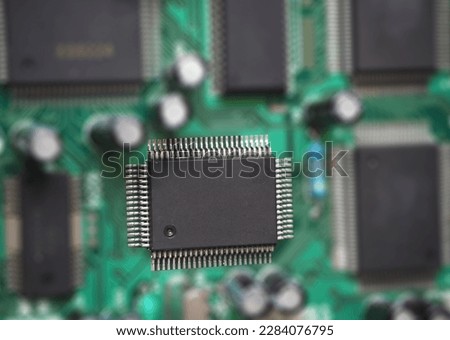 Microchip on the blurred electronic motherboard.
Semiconductor and chip production background. 