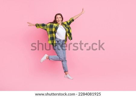 Full size photo of optimistic satisfied girl with straight hairdo dressed shirt flying hands wings isolated on pink color background