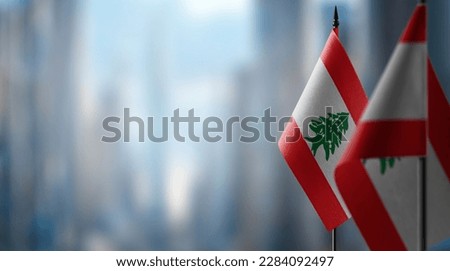 Small flags of the Lebanon on an abstract blurry background.