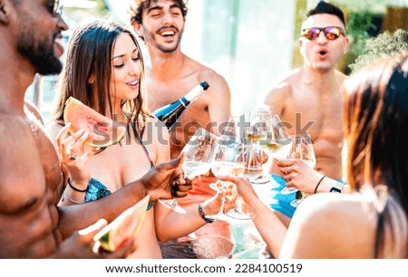 Trendy friends group drinking white wine champagne at private pool side party - Life style vacation concept with young men and women having fun together on summer day at luxury resort - Bright filter