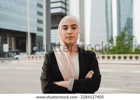 Young muslim business woman wearing hijab and looking serious on camera outside of office building Royalty-Free Stock Photo #2284127405