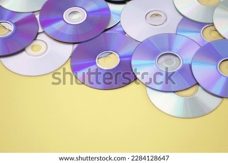Lots of old CDs are laid out as a background. Bright background. Vintage.