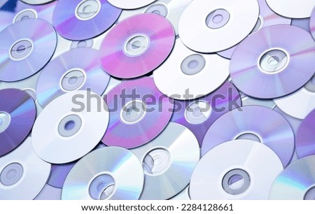 Lots of old CDs are laid out as a background. Bright background. Vintage.