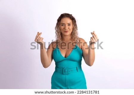 Young woman pretends to hold something with two fingers
