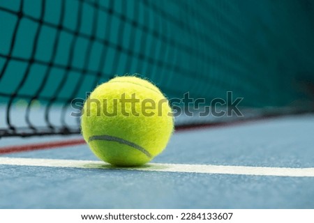 Tennis ball on blue tennis court. the concept of a sporty lifestyle. Royalty-Free Stock Photo #2284133607