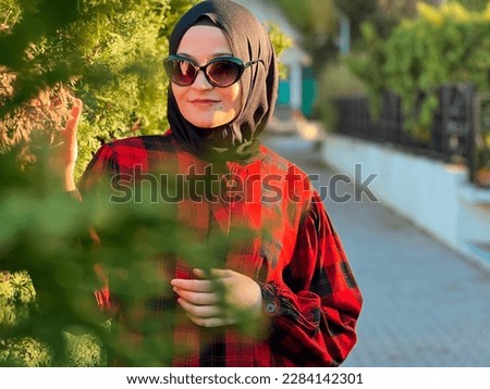 Beautiful Muslim model enjoys nature, breathes fresh air in summer garden. High quality photo