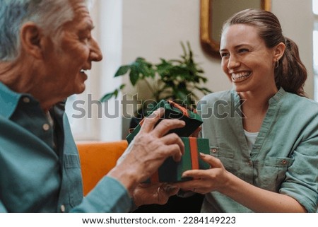 Senior man giving gift to his granddaughter.