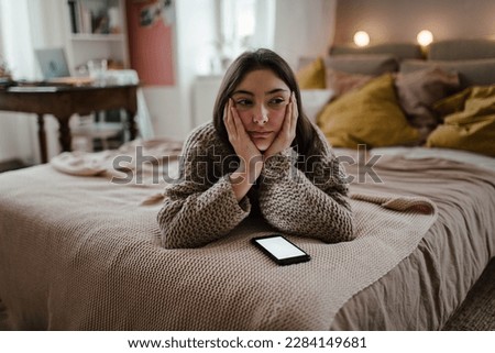 Young teenage girl with smartphone in the room. Royalty-Free Stock Photo #2284149681