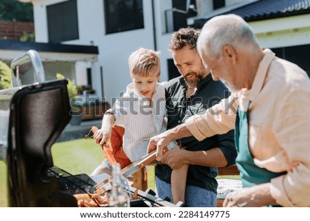 Multi generation family grilling outside on backyard in summer during garden party Royalty-Free Stock Photo #2284149775