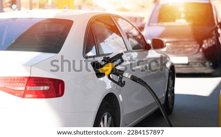 Refuel cars at the fuel pump. The driver hands, refuel and pump the car's gasoline with fuel at the petrol station. Car refueling at a gas station. Royalty-Free Stock Photo #2284157897