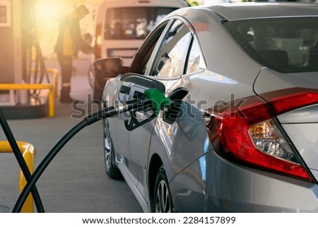 Refuel cars at the fuel pump. The driver hands, refuel and pump the car's gasoline with fuel at the petrol station. Car refueling at a gas station. Royalty-Free Stock Photo #2284157899