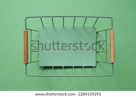 Empty basket with copy space on green background. top view