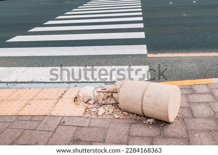 Car accident at pedestrian zebra crossing. Broken and crashed barrier pillar