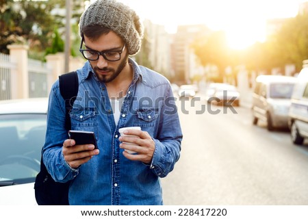 Outdoor portrait of modern young man with mobile phone in the street. Royalty-Free Stock Photo #228417220