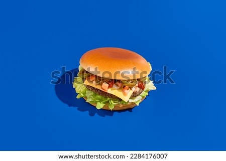 Health-conscious alternative meat burger with jalapeno  fresh greens on blue. Modern minimalist food photography, horizontal composition. Indulge in eco-friendly, protein-packed, veggie burger.