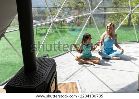 mother and daughter yoga in glamping dome tent domestic Royalty-Free Stock Photo #2284180735