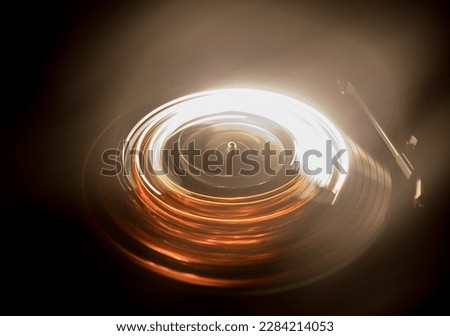 Music Dj concept. Trail of fire and smoke on vinyl record. Burning vinyl disk. Turntable vinyl record player on dark background. Selective focus