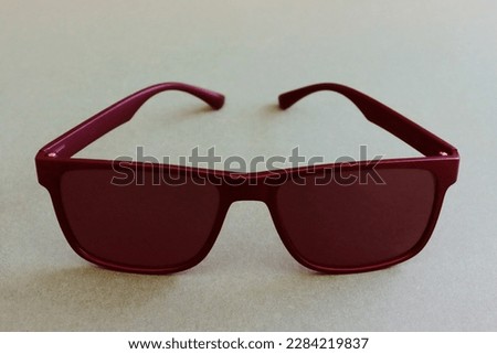 Fashionable men's red sunglasses close-up on a paper background. Abstract image of glasses. Special icons.



