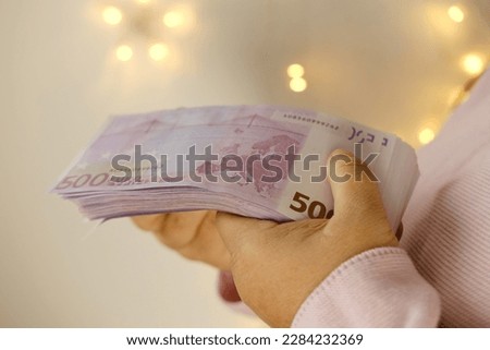closeup female hands count paper 500 euro banknotes on beautiful blurred creamy background with bokeh, payments to fund, gift for holiday, social assistance poor, save up for vacation, car, winnings