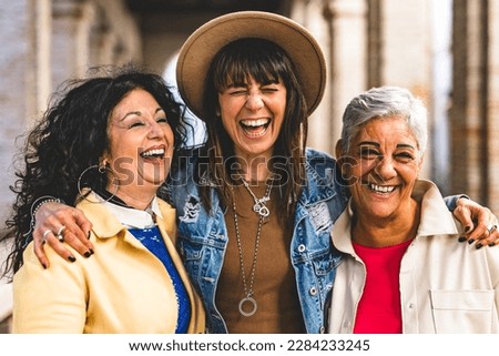 Multiracial senior women having fun together outdoor at city street- three happy mature trendy female friends hugging and laughing on urban place- Friendship lifestyle concept with elderly people Royalty-Free Stock Photo #2284233245