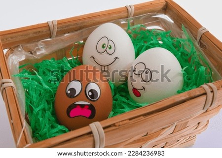 two white eggs bullying a brown one