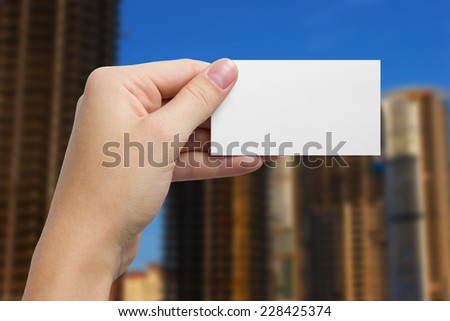 Hand holding white business card of the construction firm