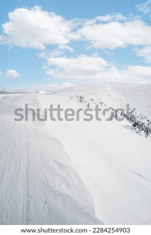 Alpine mountains landscape with white snow and blue sky. Sunset winter in nature. Frosty trees under warm sunlight. Krkonose Mountains National Park, Czech Republic ,Lucni bouda