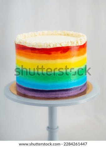 pastry chef working on a frosted cup cake with lgbt rainbow colours for wedding union party celebration. Birthday cupcake. Rainbow paper cup liners. Happy Birthday. Celebration Holidays. LGBT pride.