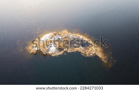 Aerial view of a beautiful small island in the sea at sunset