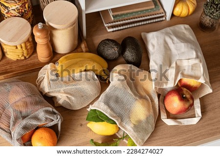 Fruits in reusable bags on kitchen table. Sustainable, zero waste, healthy lifestyle, personal environmental detox. Royalty-Free Stock Photo #2284274027