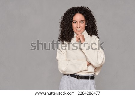 Young adult smiling latin professional business woman, happy hispanic businesswoman female model leader manager standing looking at camera isolated on light brown background, portrait.