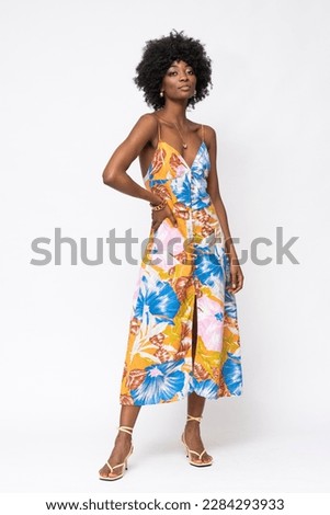 Fashionable African woman with curly hairs and floral dress on isolated white background. Royalty-Free Stock Photo #2284293933