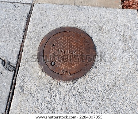 City water sewer metal cover cap sign drain on street or sidewalk   