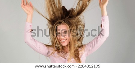 Smiling woman with long disheveled hair. Haircare. Happy girl with waving hair. Fashion woman hairstyle. Female model with messy unbrushed dry hair in hands. Damaged hair, health and beauty concept. Royalty-Free Stock Photo #2284312195