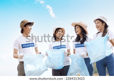 Group of Asian young people volunteer helping to collecting or picking up a plastic bottle garbage on the ground in park. Sustainability and environment conservation concept. Royalty-Free Stock Photo #2284313423