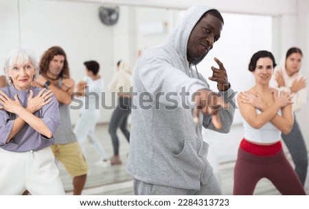 Group of multinational people practicing new modern dance techniques at a dance school during a lesson