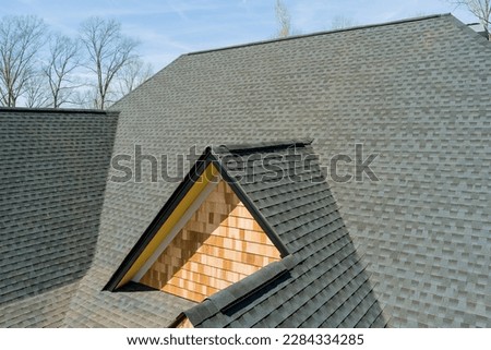 When installing top covering of asphalt shingles on new house quality roof work is inspected Royalty-Free Stock Photo #2284334285
