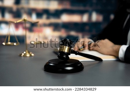 Focus wooden gavel hammer on blurred background of lawyer working or studying at library. Lawful hammer for righteous and equality judgment by lawmaker and attorney. Equilibrium