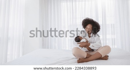 Close up portrait of beautiful young African American  mother holding sleep newborn baby in hospital bed room. Healthcare medical love black afro woman lifestyle mother's day, breast with copy space. Royalty-Free Stock Photo #2284338893