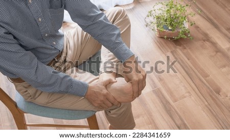 A barefoot man sitting on a chair.A man giving a foot massage.People with gout. Royalty-Free Stock Photo #2284341659