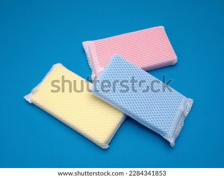 Colorful kitchen sponges shot against a blue background