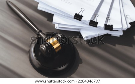 Closeup top view black wooden gavel hammer and legal document on wooden office desk background as justice and legal system for lawyer and judge, Legal authority and fairness in trials. equility