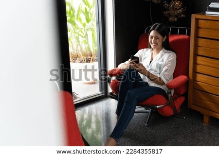 Young beautiful Asian woman relaxing. Portrait confident asian women smiling use mobile phone messaging at home. Shopping online on smartphone