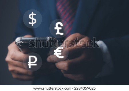 Global currency exchange and forex. Businessman using mobile phone with currency icon ( dollar, euro, pound, and ruble). Currency exchange and global currencies concept. Royalty-Free Stock Photo #2284359025
