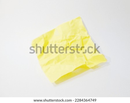 A crumpled yellow paper on white background 